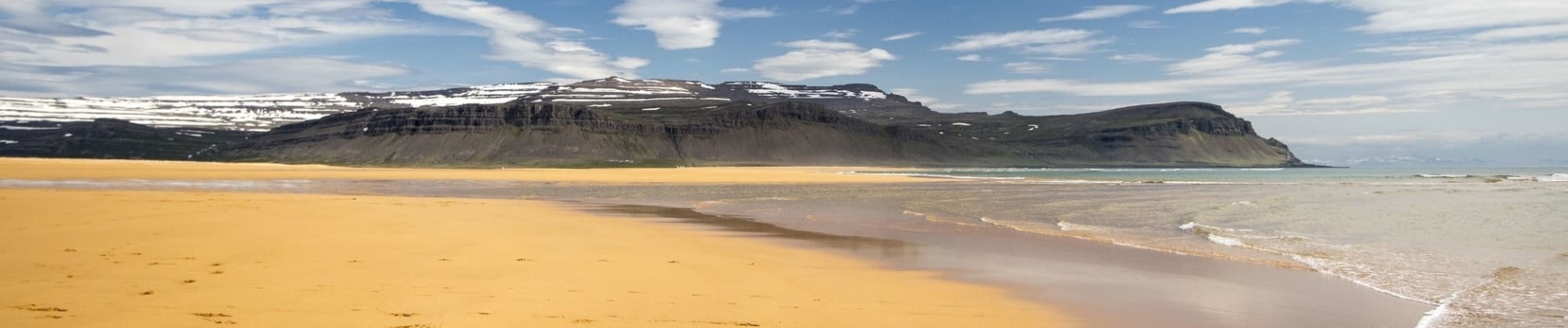 Iceland destinations - yellow sand beach and snowy mountains
