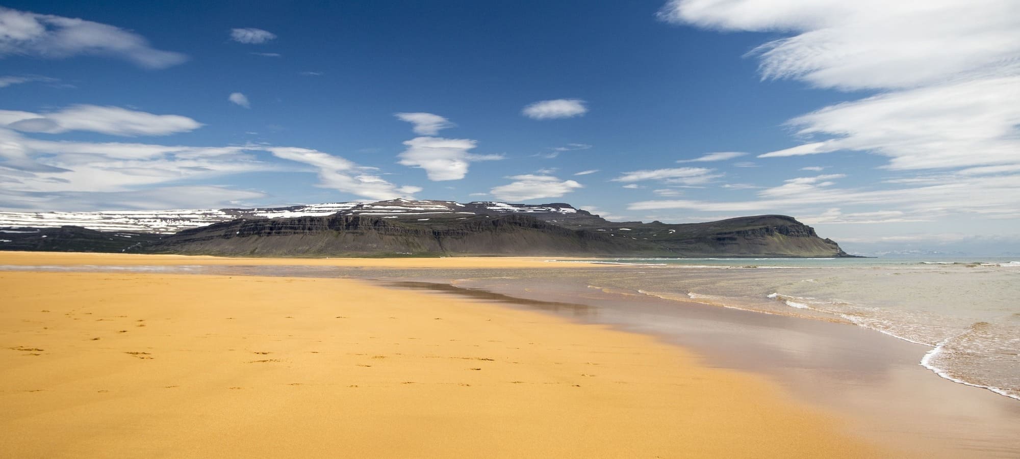 Iceland destinations - yellow sand beach and snowy mountains